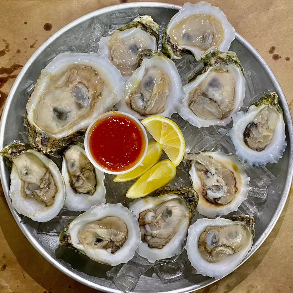 Fresh oysters on the half shell, served on ice with cocktail sauce and lemon wedges.