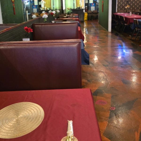 Interior view of Cyndy's Seafood restaurant with red tablecloths, brown booths, and a patterned floor.