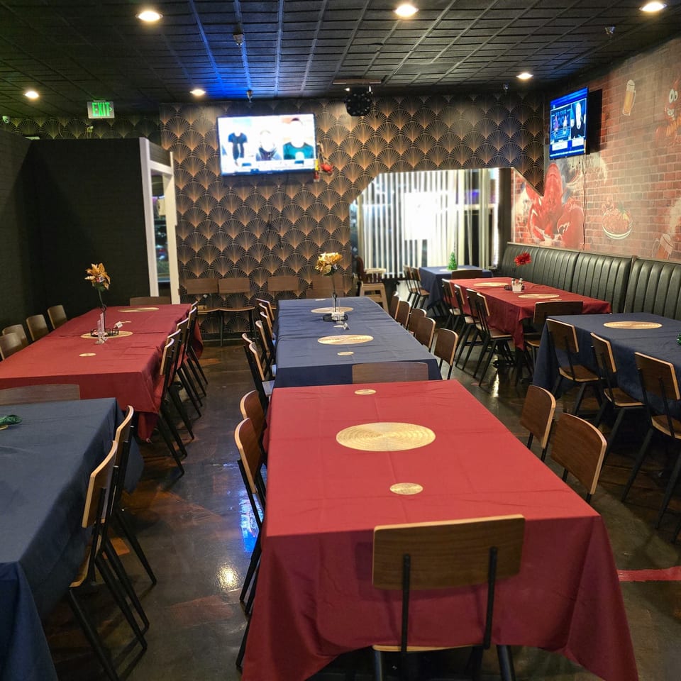 Interior of Cyndy's Seafood restaurant with long tables covered in red and blue tablecloths.