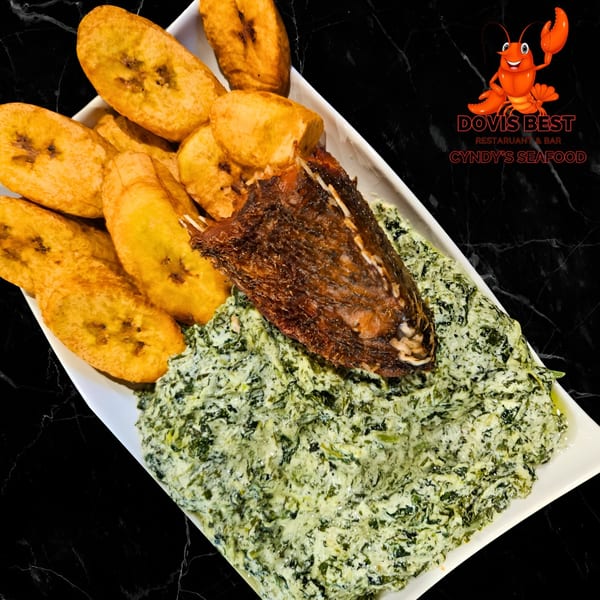 Fried fish with creamy spinach and fried plantains on a white rectangular plate.