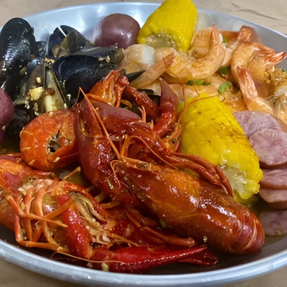 A seafood boil with crawfish, mussels, shrimp, corn on the cob, potatoes, and sausage.